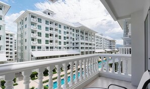 Ein modernes Hotel mit mehreren Etagen, Balkonen und einem Poolbereich.
