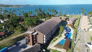 Ein Resort mit einem großen Gebäude, einem Schwimmbad und Blick auf den Ozean.