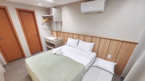 A hotel room with a bed, a bedside table, a wardrobe, and an air conditioning unit. - Bangalo no Carneiros Atlantico by CTA (Tamandaré)