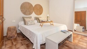 Une chambre à coucher avec un lit, une table de chevet et un miroir.