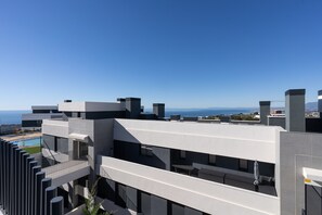 A modern building with balconies, a pool, and a view of the sea. - Med Blue by Time & Home (Marbella)