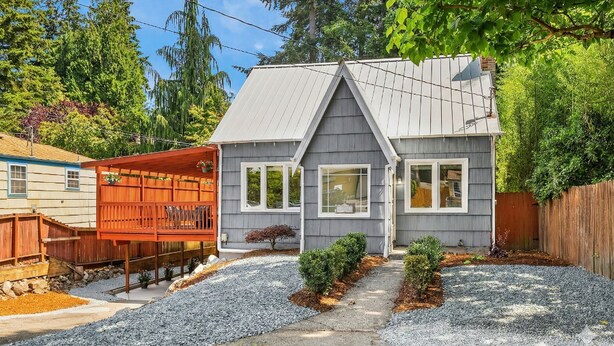 A residential house with a grey roof, white trim, and a small front yard with gravel and plants. - ​The Seattle Scenes House: 5-Suite Boutique Home near Light Rail (Seattle)