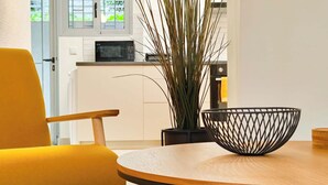 Eine moderne Küche mit weißen Schränken, einer Mikrowelle und einem Blumentopf.