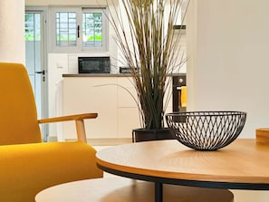 A modern kitchen with white cabinets, a microwave, and a potted plant. - Vibrant Flat in Voula Center (Voula)