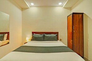 A hotel room with a bed, a wardrobe, a nightstand, and a mirror. - Hotel O Madhapur - Borabanda (Hyderabad)