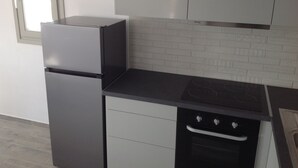 A kitchen with a refrigerator, oven, and a countertop. - Liopi Village Andros B (Ormos Korthiou)