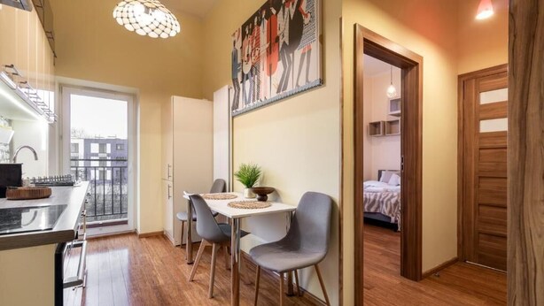 A compact living space with a kitchenette, dining area, and a bedroom. - Malila Premium Apartments Traugutta (Kraków)
