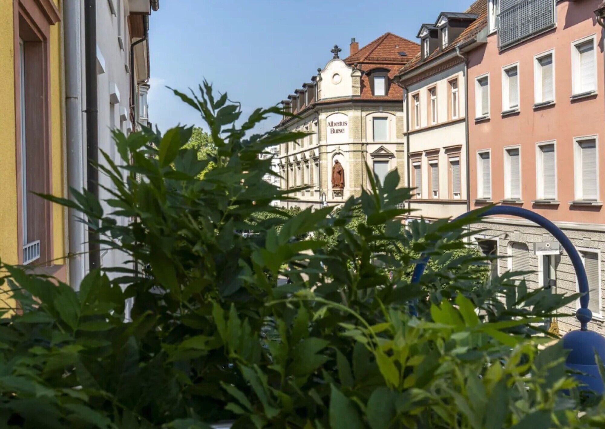 Ein Gebäude mit der Aufschrift 'Albertius Buse', das einen klassischen Baustil mit einem zentralen Turm und zahlreichen Fenstern aufweist.