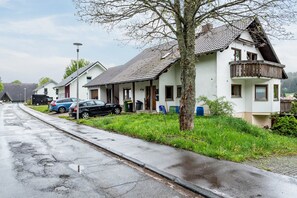 A row of white houses with sloped roofs, a tree in front, and parked cars along the street. - Holiday Apartment for 3 People in Schönwald, Black Forest (Schönwald im Schwarzwald)