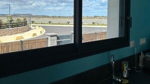 A kitchen with a window overlooking a parking area and distant landscape. - Seaside house adjoining the beach Leucate La Franqui (Leucate)