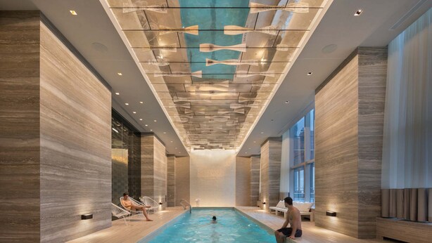 Ein Innenpool mit modernem Design, großen Fenstern und einer Decke mit einem einzigartigen Muster.