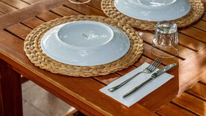 A wooden dining table with two plates, cutlery, and glassware. - Gokcen Hotel & Aparments (Fethiye)