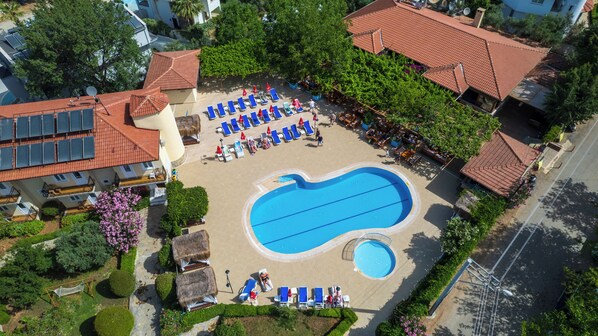 An aerial view of a resort with a swimming pool, sun loungers, and a covered seating area. - Gokcen Hotel & Aparments (Fethiye)