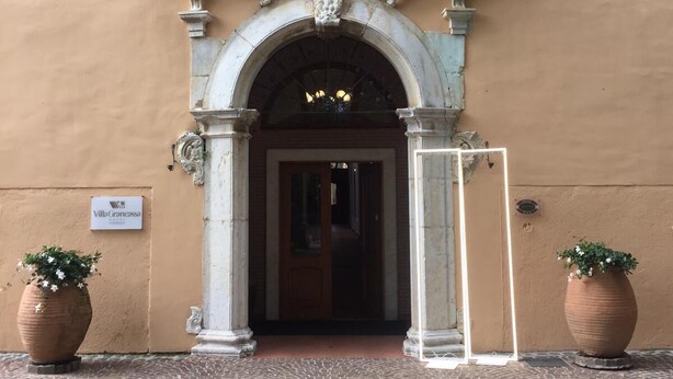 A building entrance with an ornate stone archway, a sign reading 'Villa Grancassa,' and two potted plants on either side. - VillaGrancassa Historic home from 1853 at the foot of the National Park (San Donato Val di Comino)