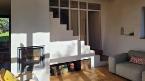 Un intérieur moderne avec une cheminée, un escalier et un canapé.