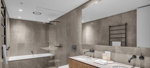 A modern bathroom with a bathtub, a sink, and a shower. - Black Bear 402 - Central Village (Thredbo)