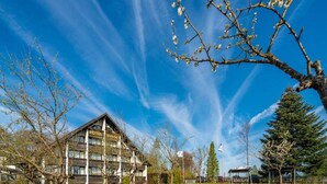 Un hotel con fachada de madera, varios balcones y un cielo azul despejado.