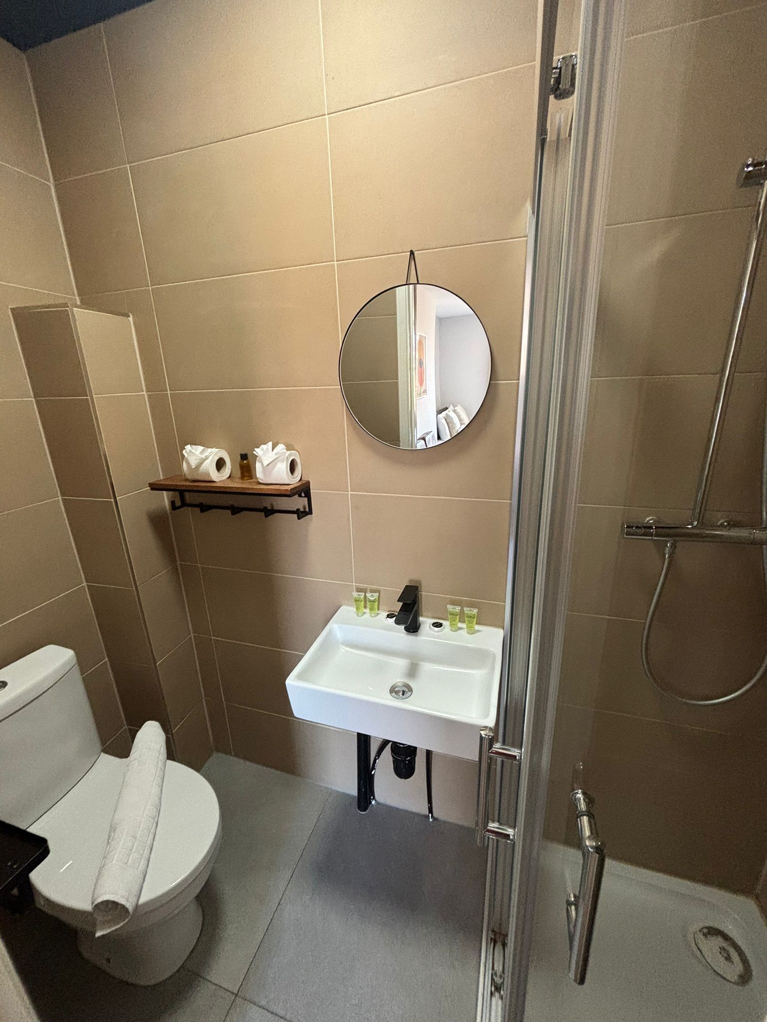 Un bagno con il water, lavandino, specchio e doccia.