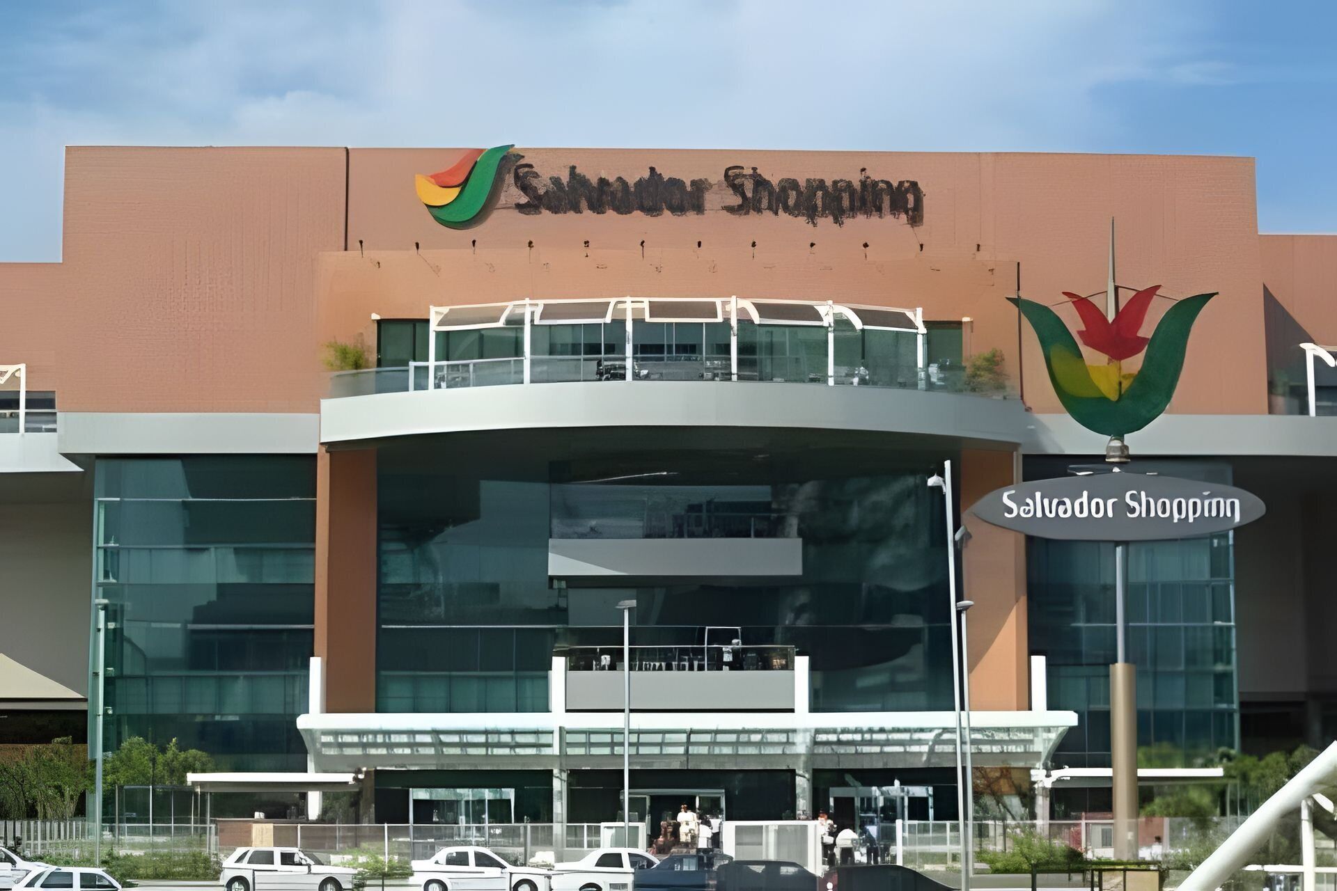 A shopping center with a prominent sign reading 'Salvador Shopping' and a colorful logo above it.