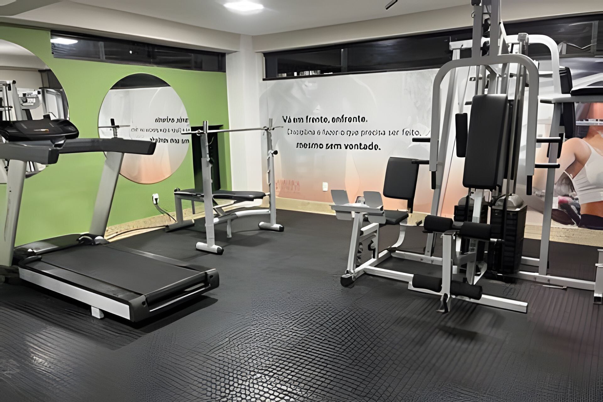 A gym with treadmills, weight machines, and benches.