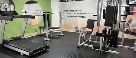A gym with treadmills, weight machines, and benches.