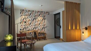 Habitación de hotel con cama, escritorio, silla, un panel decorativo y un panel de madera.
