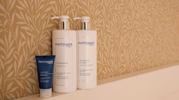 Trois produits PHYTOMER présentés sur une étagère, avec un mur à motifs en arrière-plan.