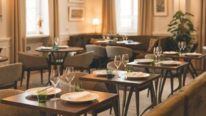 Een restaurant met gedekte tafels, stoelen en een bank.