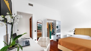 A bedroom with a bed, a desk with a laptop, a chair, a wardrobe, and a potted plant. - Estate4home - Casa Marelia (Sorrento)
