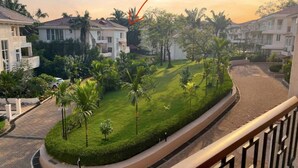 A residential area with houses, a curved pathway, and a lawn with palm trees. - 2 BHK/3 BED Luxury Private Pool Villa with view (Siolim)