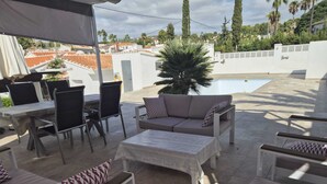 Patio esterno con piscina, posti a sedere e vista sul quartiere.