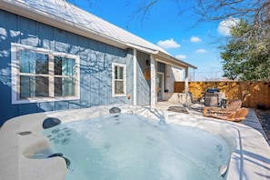 A backyard with a hot tub, wooden deck, and outdoor furniture. - Broken Windmill Cottage - Hot Tub, 5 Min to Main (Fredericksburg)