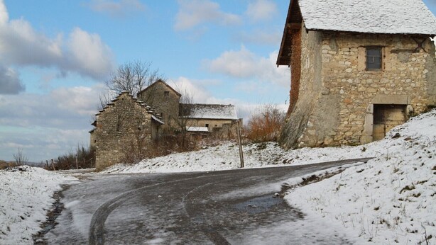 A rural road with stone buildings, one with a snow-covered roof, and a clear sky. - Rural Cottage at Claudette's (Briord)