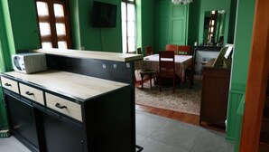 A kitchen with a microwave, a sink, and a dining area with a table and chairs. - Rural Cottage at Claudette's (Briord)