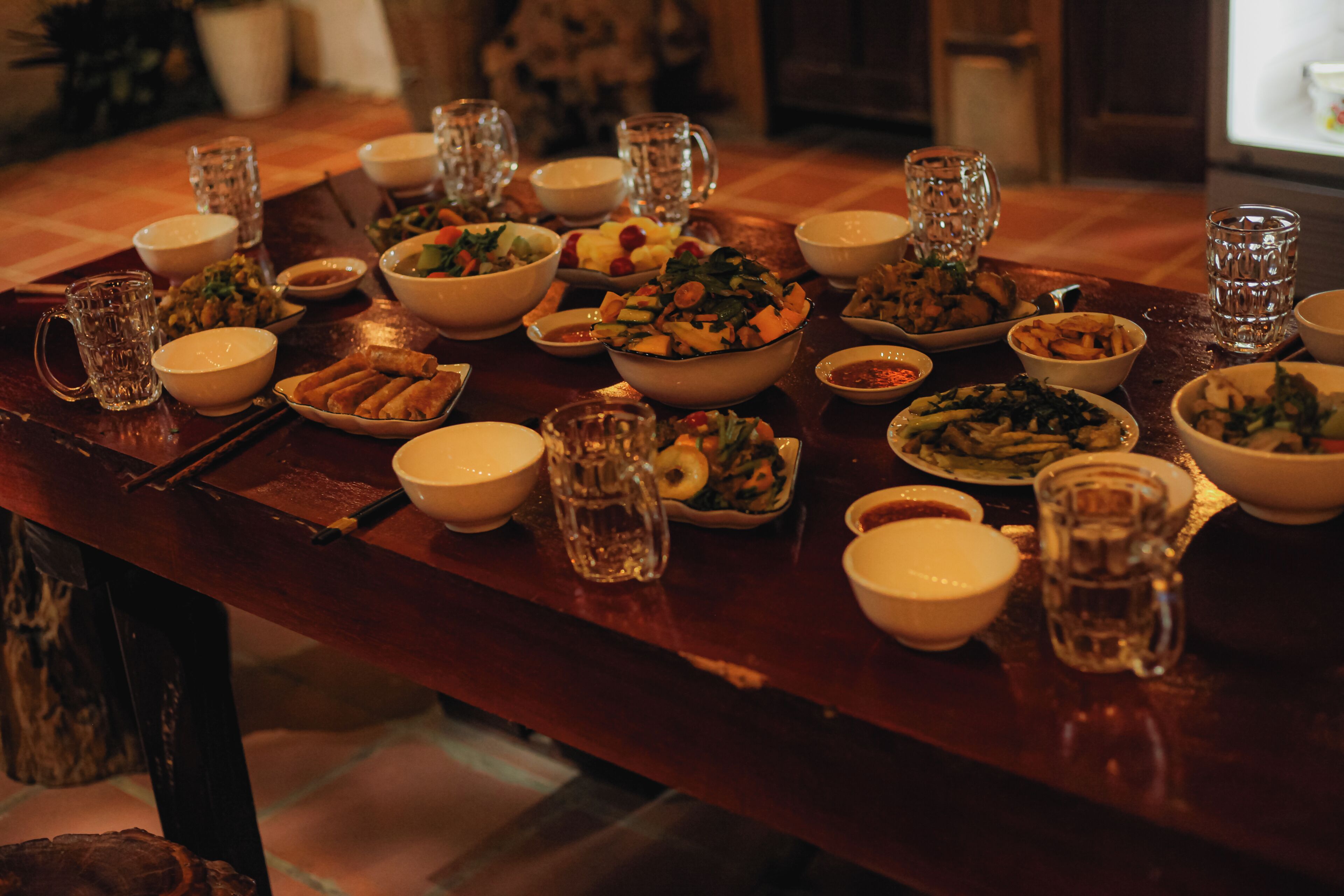 A dining table set with various dishes and beverages, indicating a meal setting.
