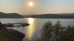 Ein Yachthafen mit vertäuten Booten, umgeben von Hügeln und einem klaren Himmel.
