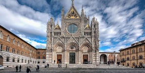 Una maestosa cattedrale con elaborata architettura gotica, ampie finestre ad arco e una cupola centrale imponente.
