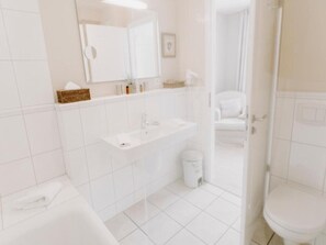 A modern bathroom with a white sink, mirror, and toilet. - Heikendorf Corner Junior Suite Sea Side (Heikendorf)