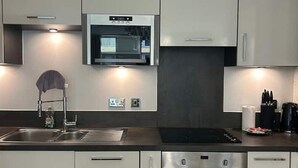 Eine moderne Küche mit Edelstahlgeräten, einer doppelten Spüle und einem eingebauten Backofen.