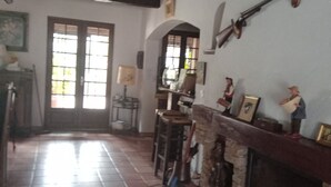 A room with a tiled floor, a wooden ceiling, a fireplace, and a mounted rifle. - Villa with spa pool 2.5 km from the sea Poolhouse barbecue (La Seyne-sur-Mer)