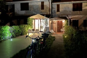 A courtyard with a patio, chairs, a table, and bicycles. - M453 - Marcelli, comfortable two-room apartment with garden (Marcelli)