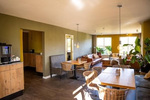 Una habitación amplia con zona de comedor, sofá y espacio para cocinar.