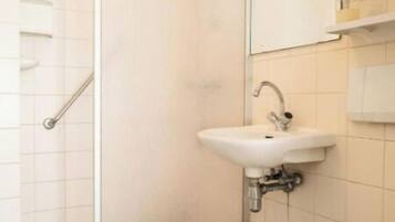 A bathroom with a toilet, sink, and shower.