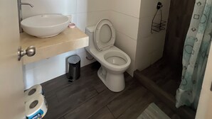 Un bagno con lavandino, water e tenda della doccia bianchi.