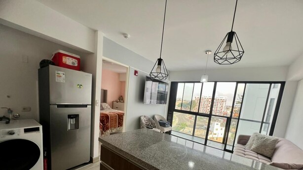 Una cucina moderna con piani in granito, lavatrice integrata, frigorifero e zona pranzo con vista.