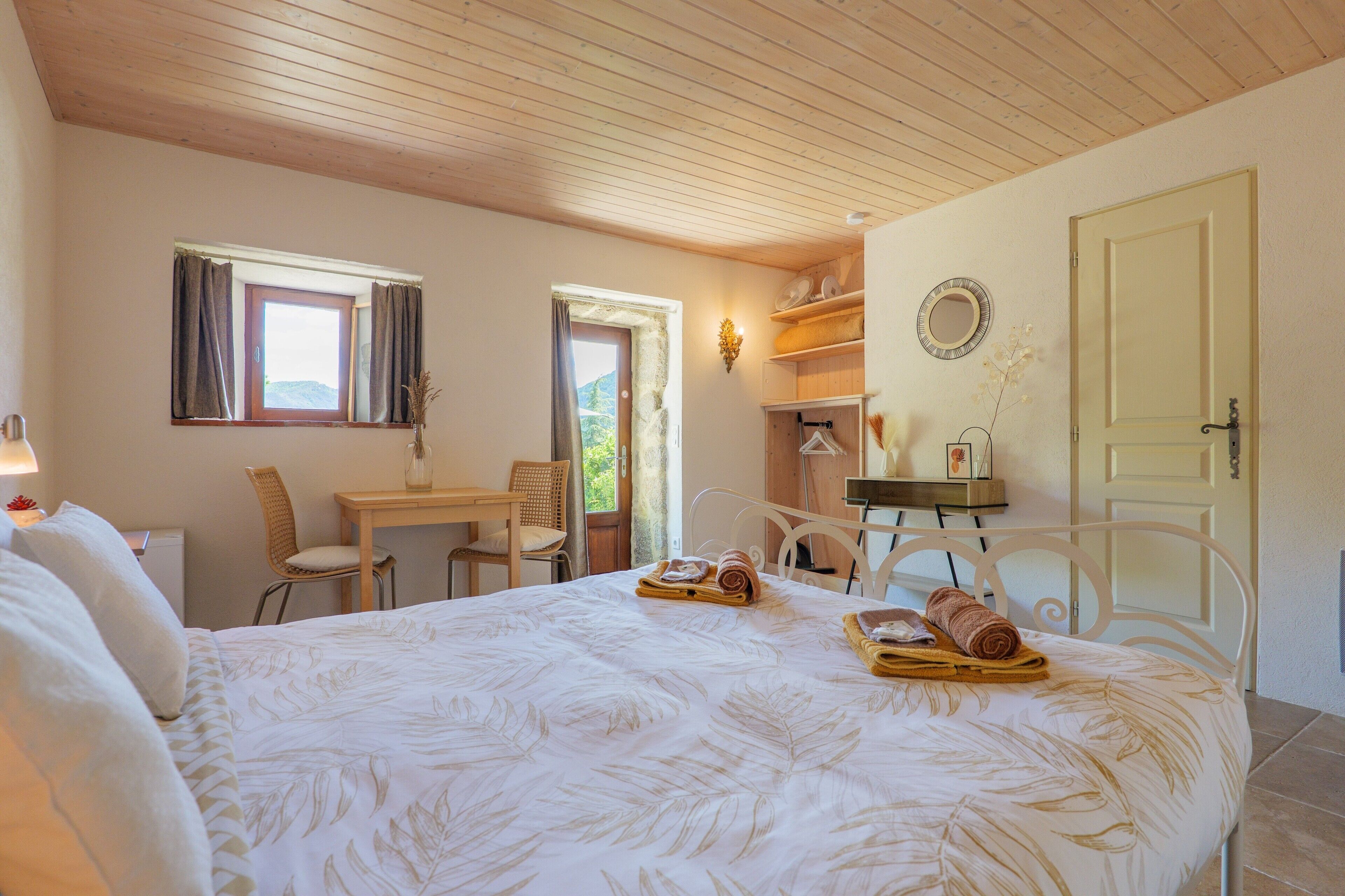 Une chambre à coucher avec un lit, un bureau, une chaise et une porte.