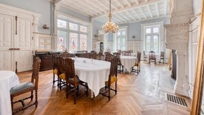 A spacious dining area with high ceilings and ornate chandeliers. - Château Optical Center (Nieuil)