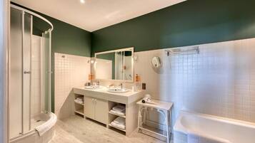 Un baño moderno con ducha, dos lavamanos, un espejo grande y una bañera.