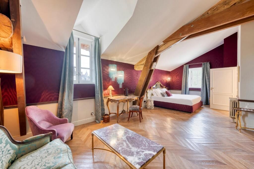 A room with a bed, a table, a chair, and a sofa.