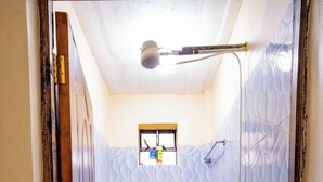 Un baño con inodoro, ducha y paredes con diseño.